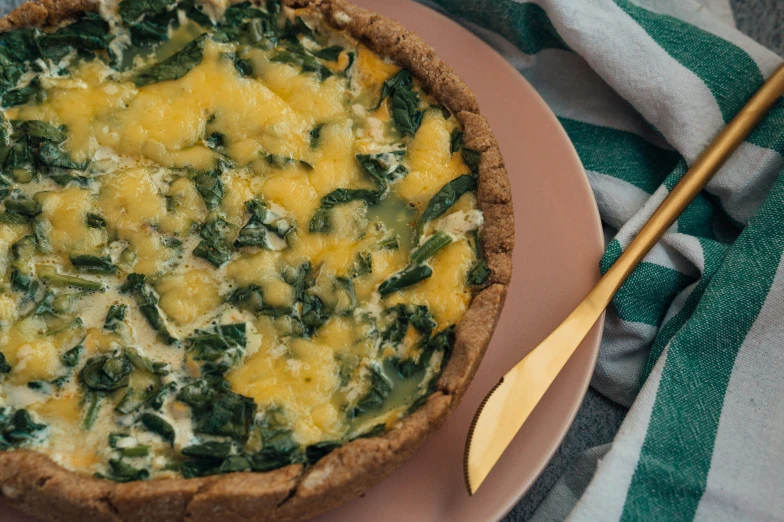 a food dish is sitting on a plate with a yellow spoon