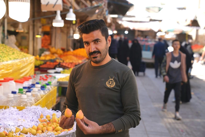 man standing in front of large assortment of fruits