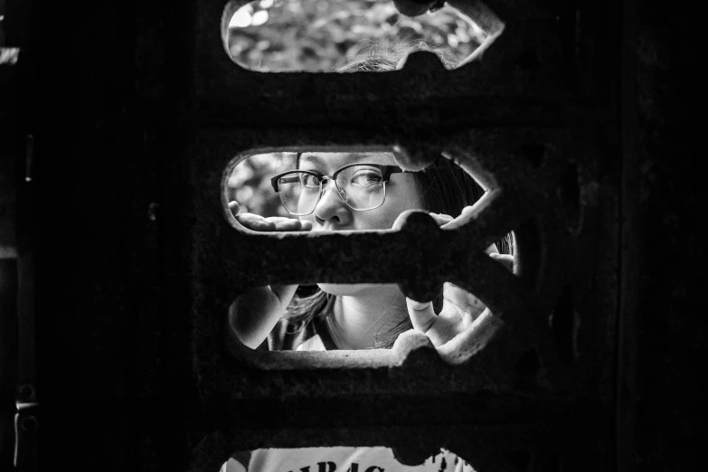 a man in glasses looks out through the window