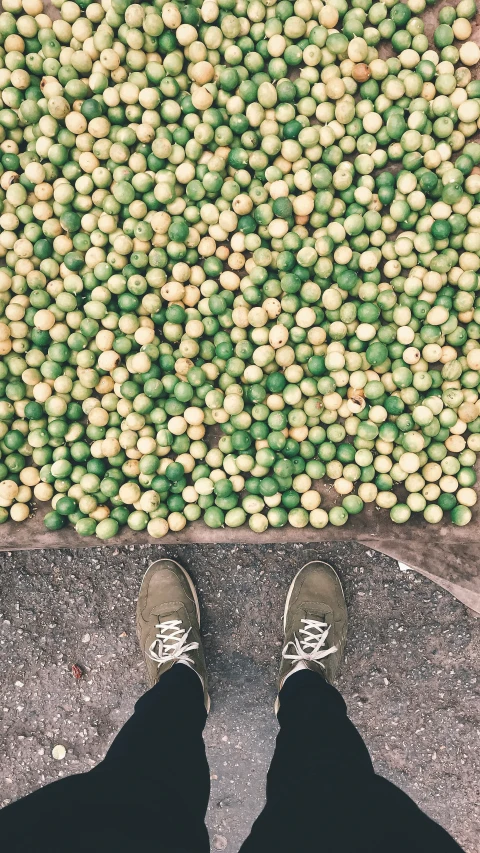 two feet standing on the ground and looking down at balls