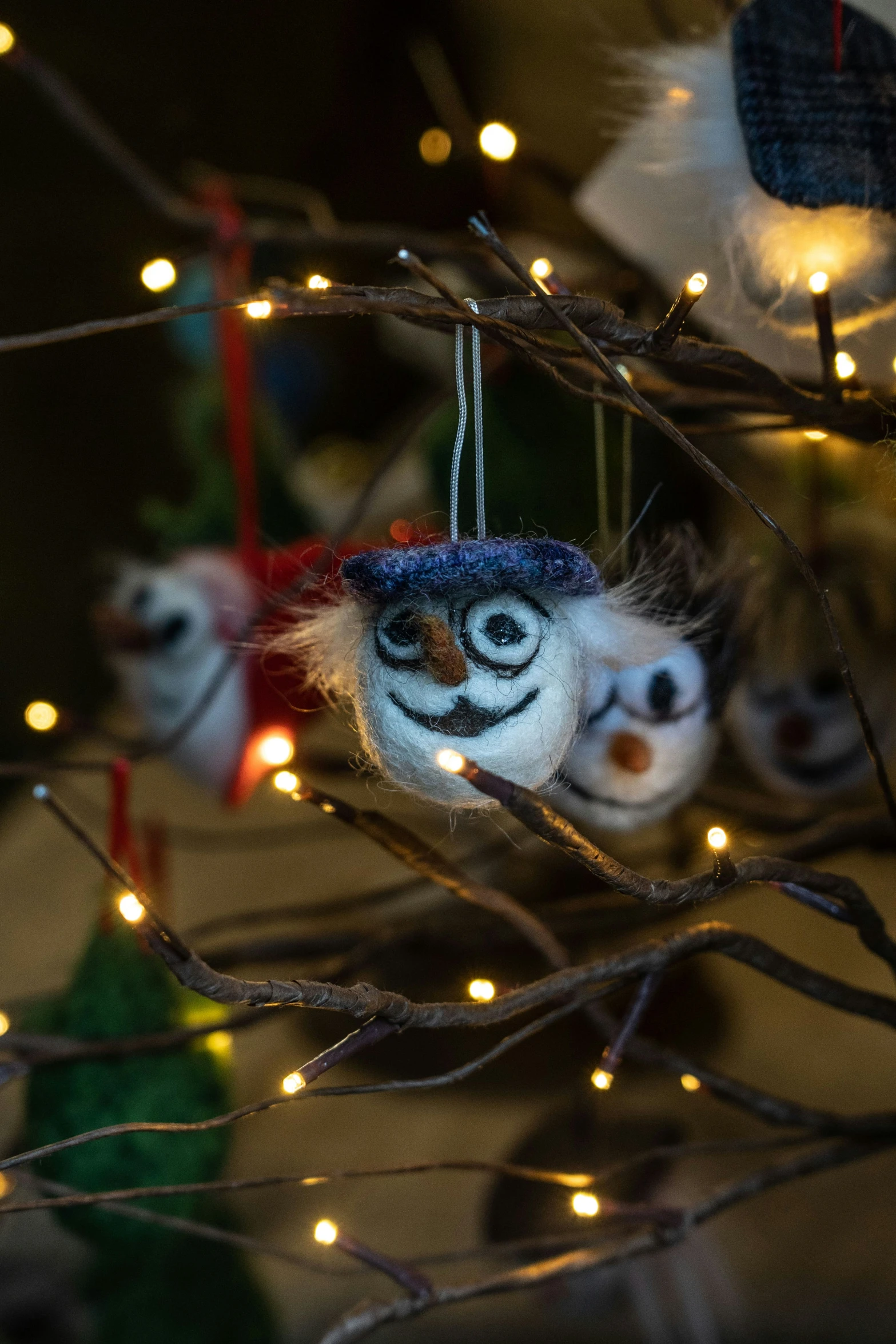 two eyes ornament hanging from a tree with light - up nches