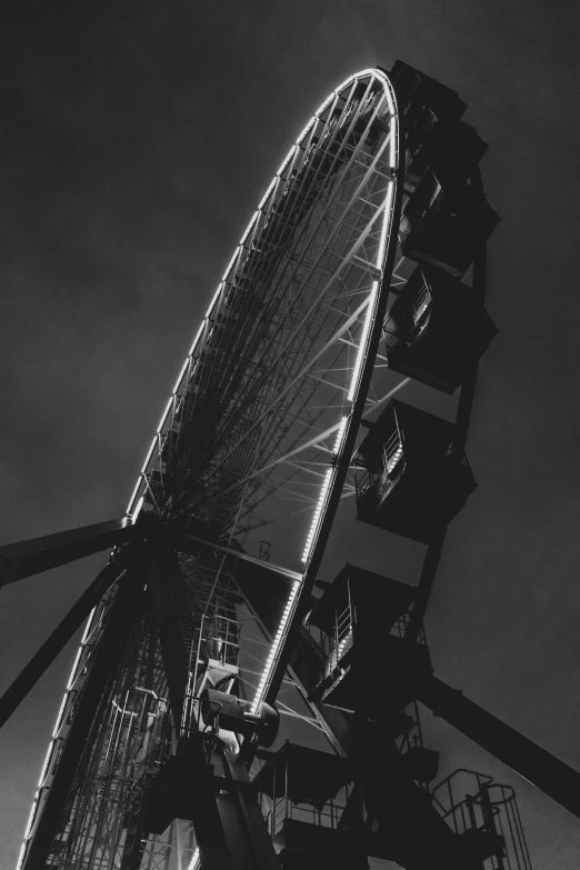 the ferris wheel is illuminated from below in black and white