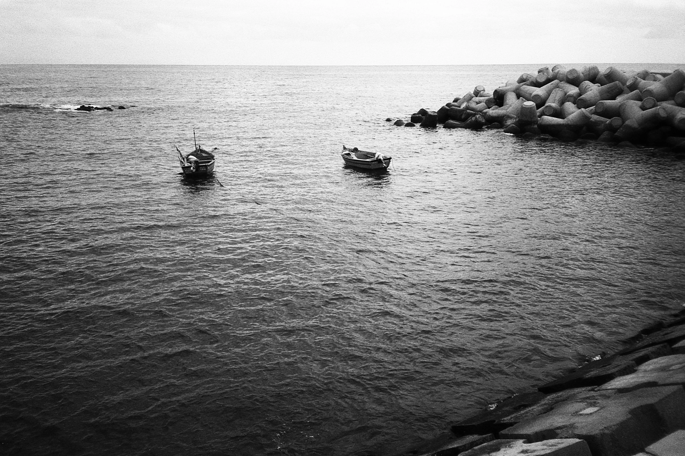 a couple of boats floating on top of the ocean