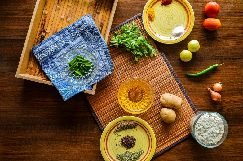 a wooden table topped with bowls and plates of food