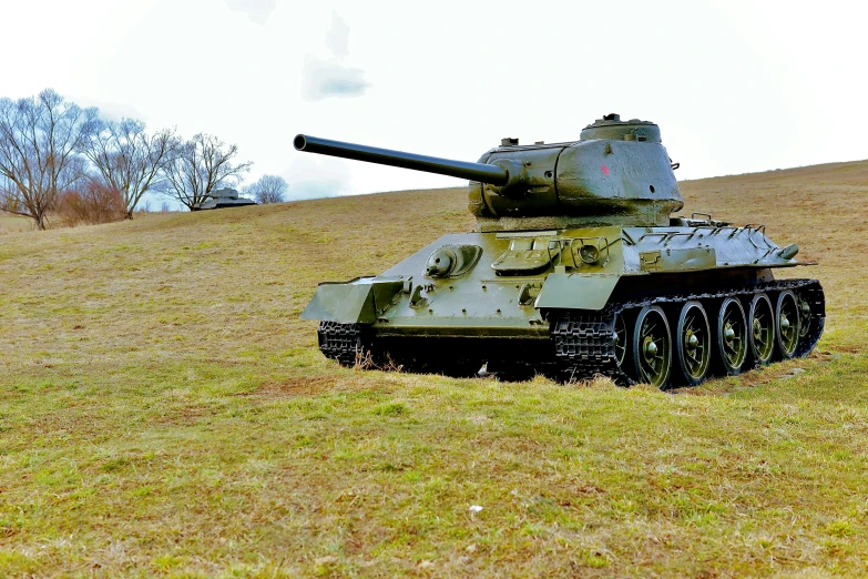 a tank on the side of a hill in a grassy field