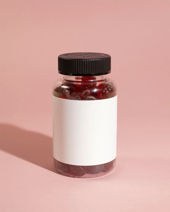 a jar filled with jam on top of a pink table