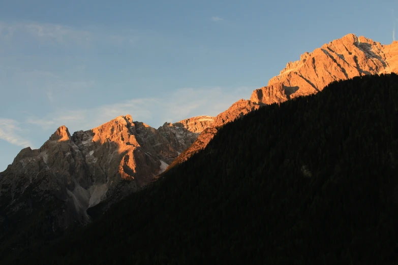 a view of some mountain side with the sun shining on them