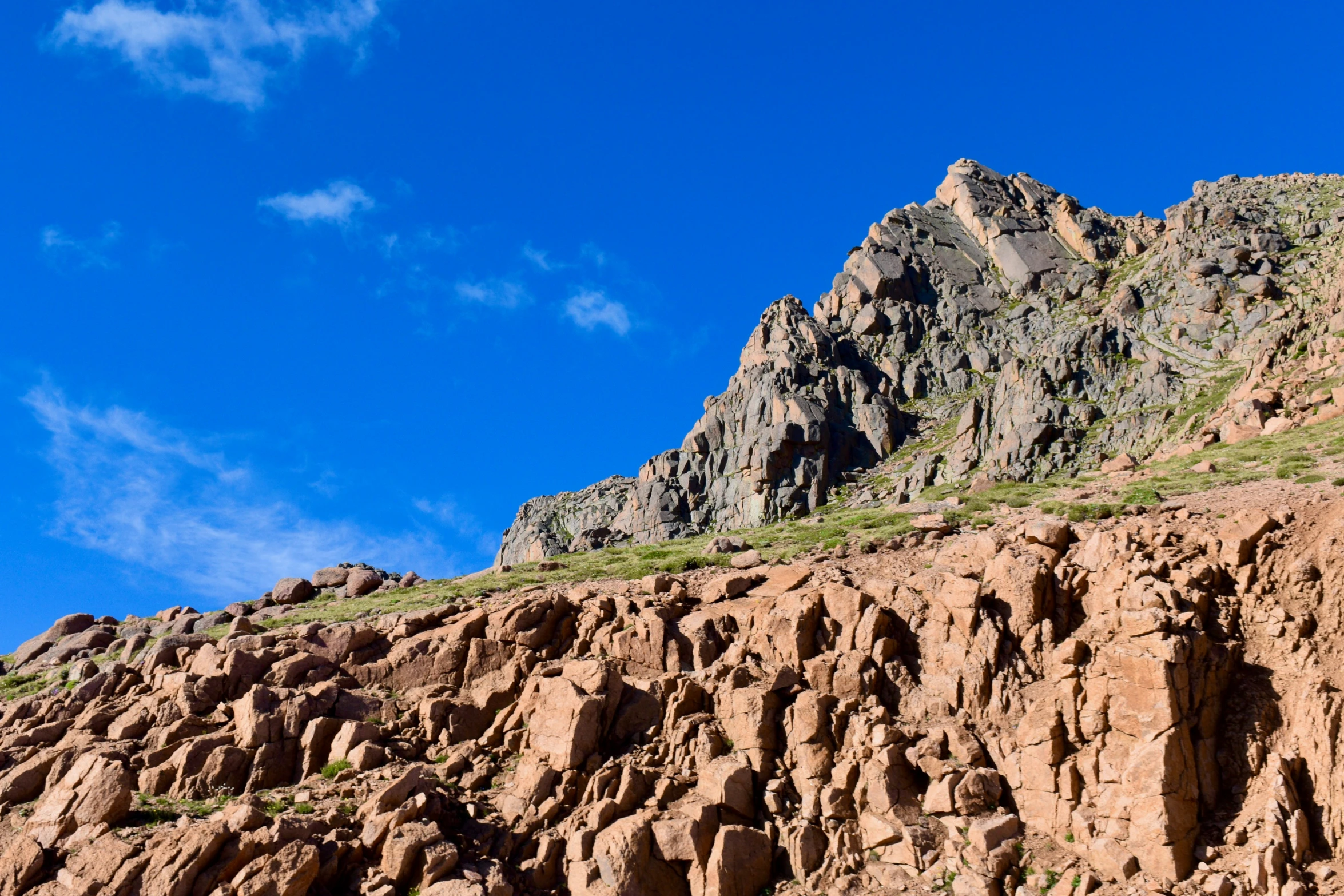 mountains and grass are growing on the steep sides of this mountain