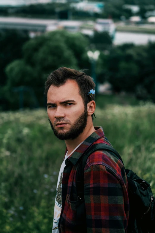 man with a flower in his hair and beard outside