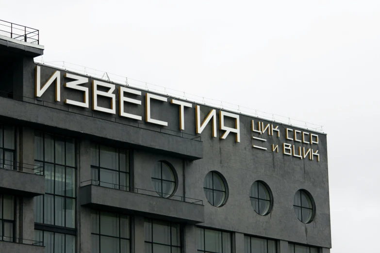 a large black building with round windows and a large sign on top