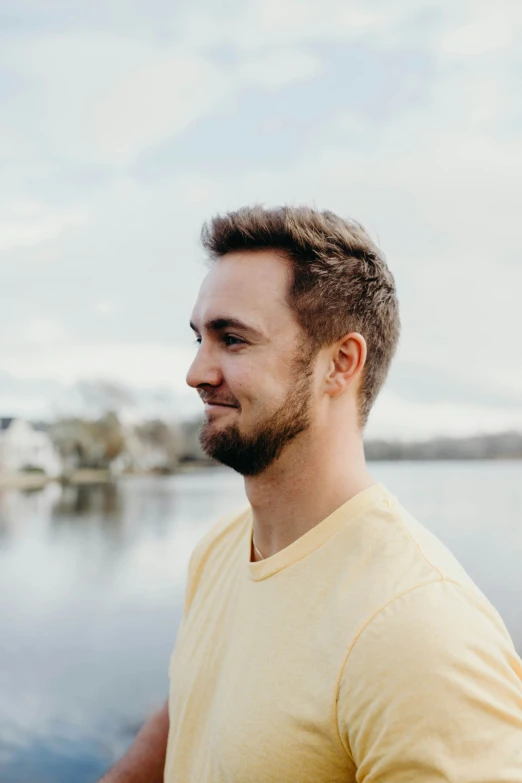 a man standing next to the water staring at soing