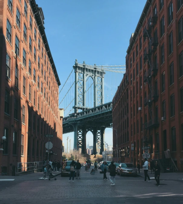 a group of people walking across a bridge