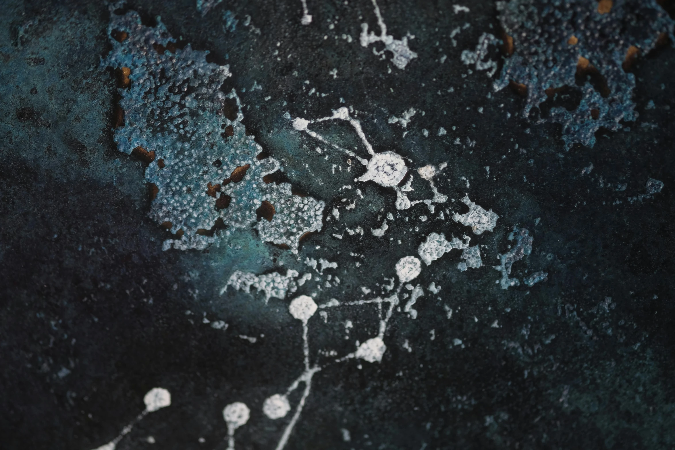 white paint and water bubbles are visible on a black surface