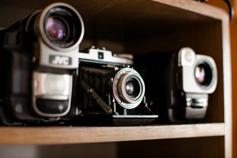 old cameras are lined up on a shelf