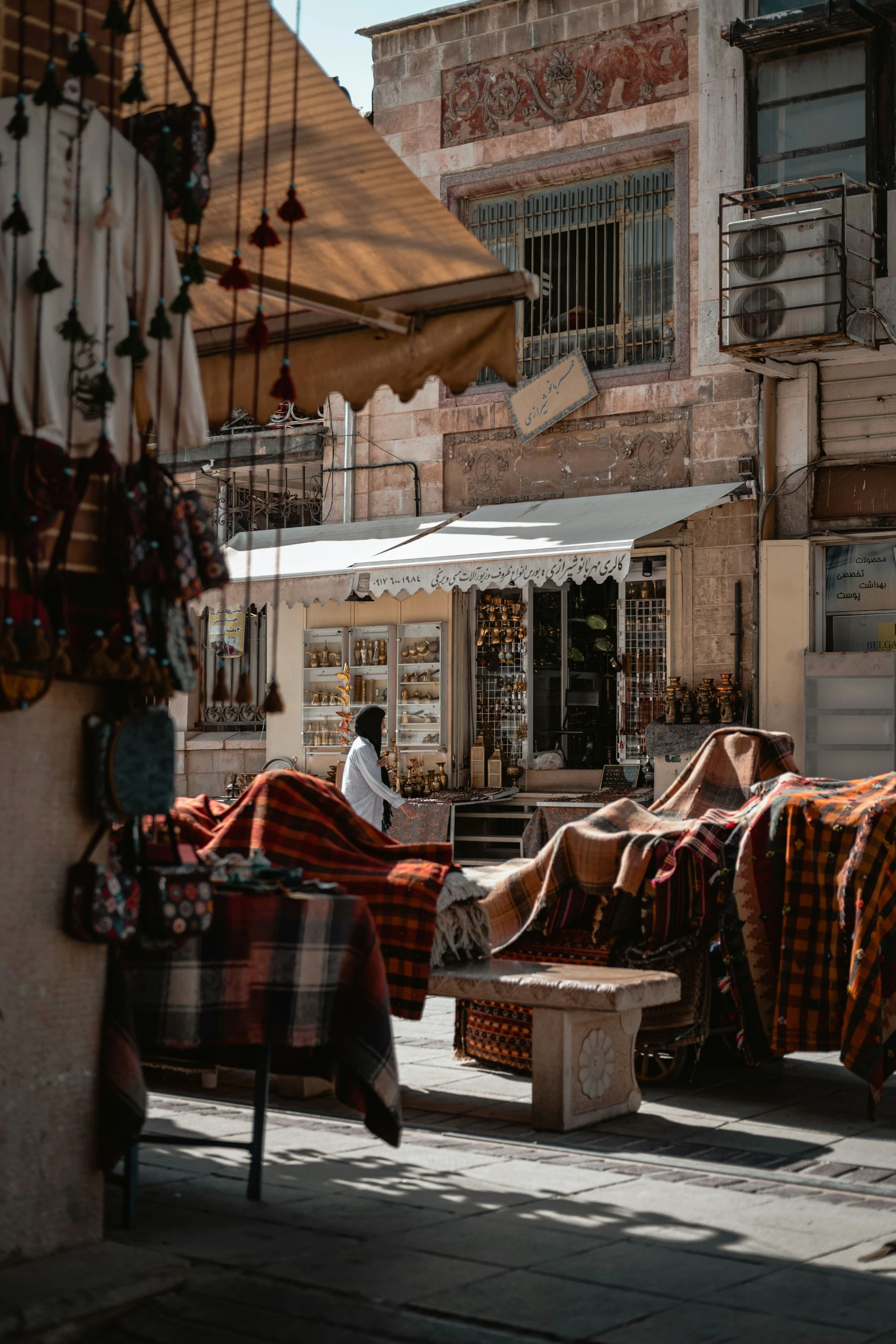 a man sitting on top of a bench covered in blankets