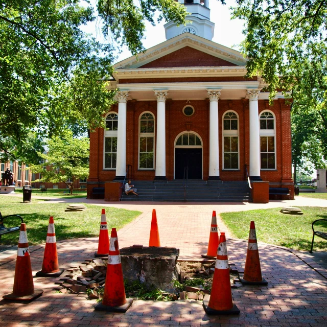 an old red brick church with pillars and a clock tower