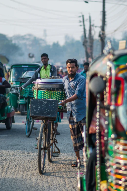 a man on a bicycle hing a cart with many food in it