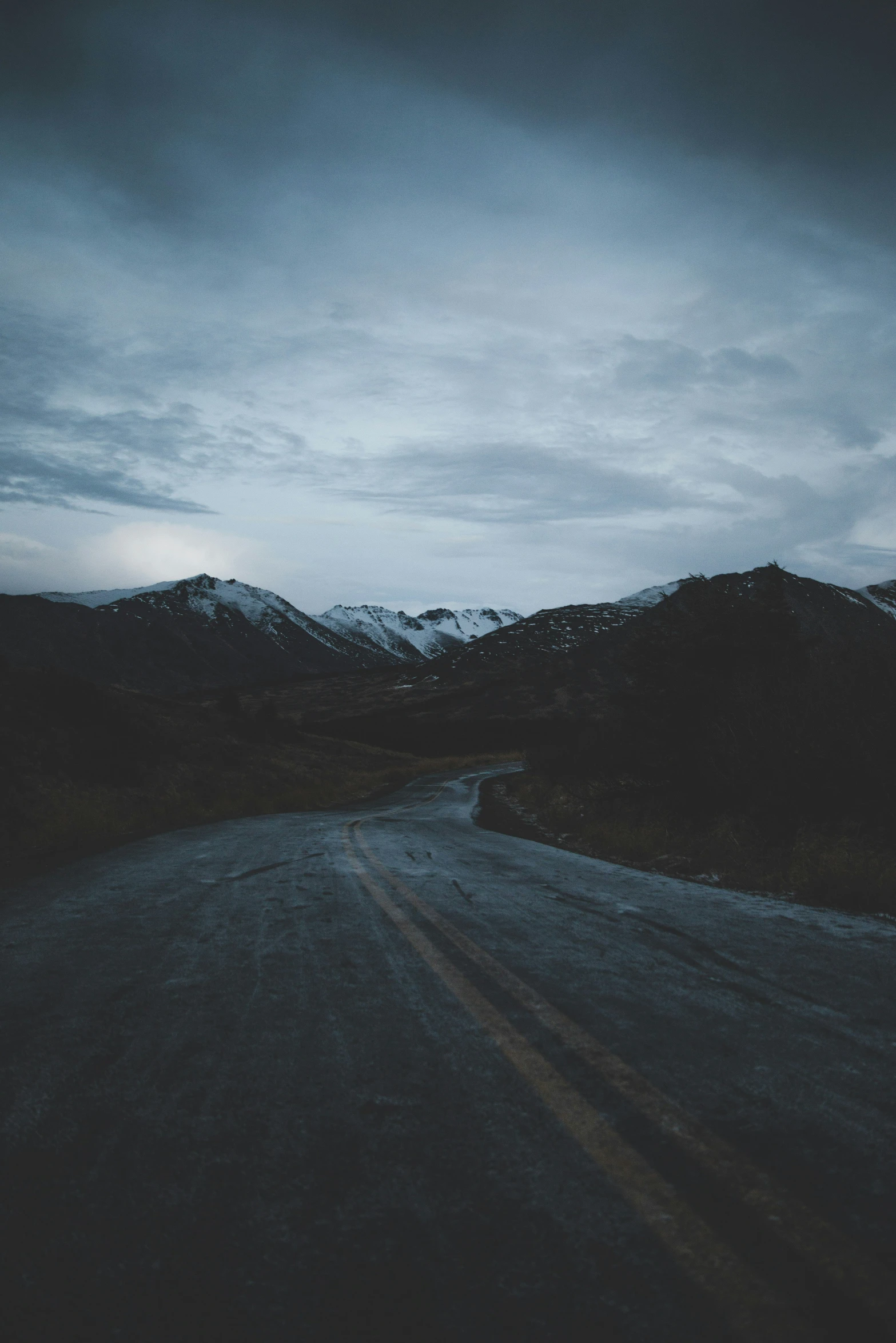 a street in the middle of an open area with mountains