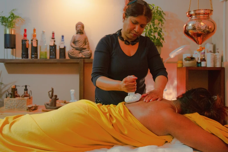 a woman getting a back massage with a man in a yellow towel
