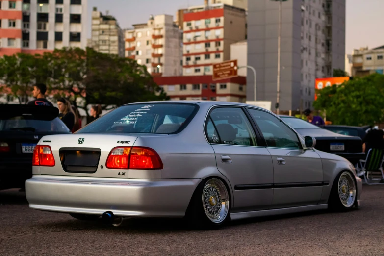 car with a custom stance and rear end lights parked in front of a line of parked cars