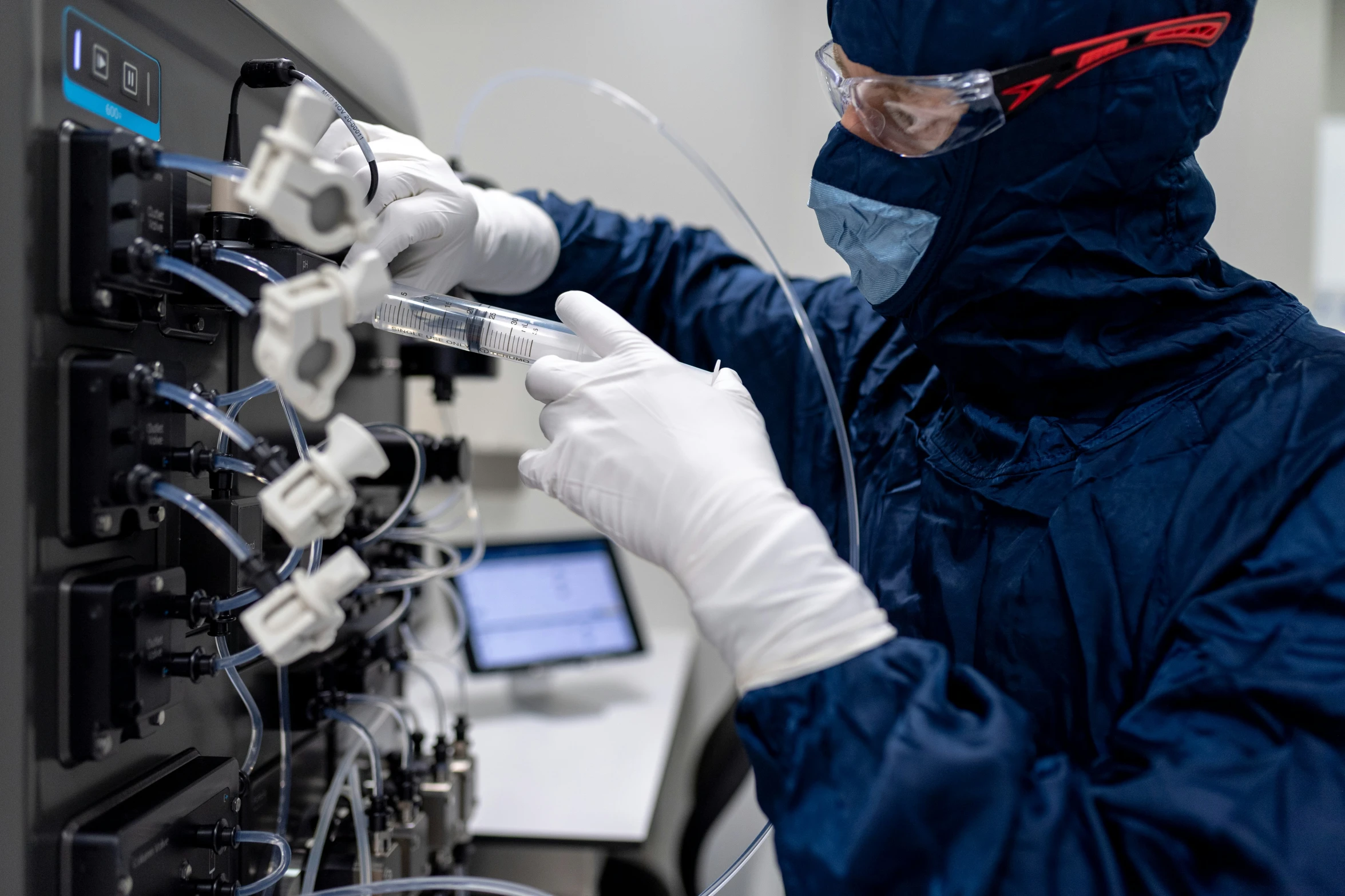 someone in a blue coat with white gloves holding a needle