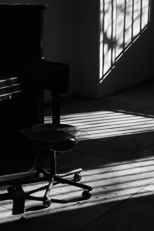 an empty chair is in front of a piano