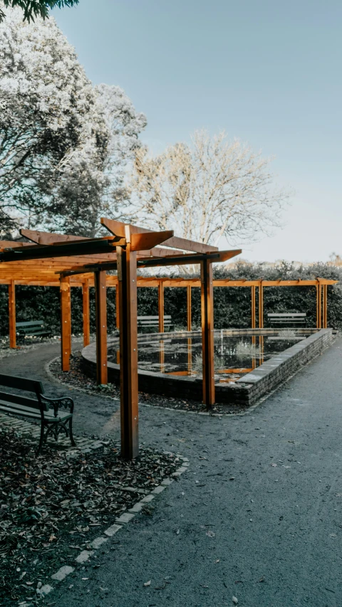 a bench sits beneath the canopy of a pavilion in the forest