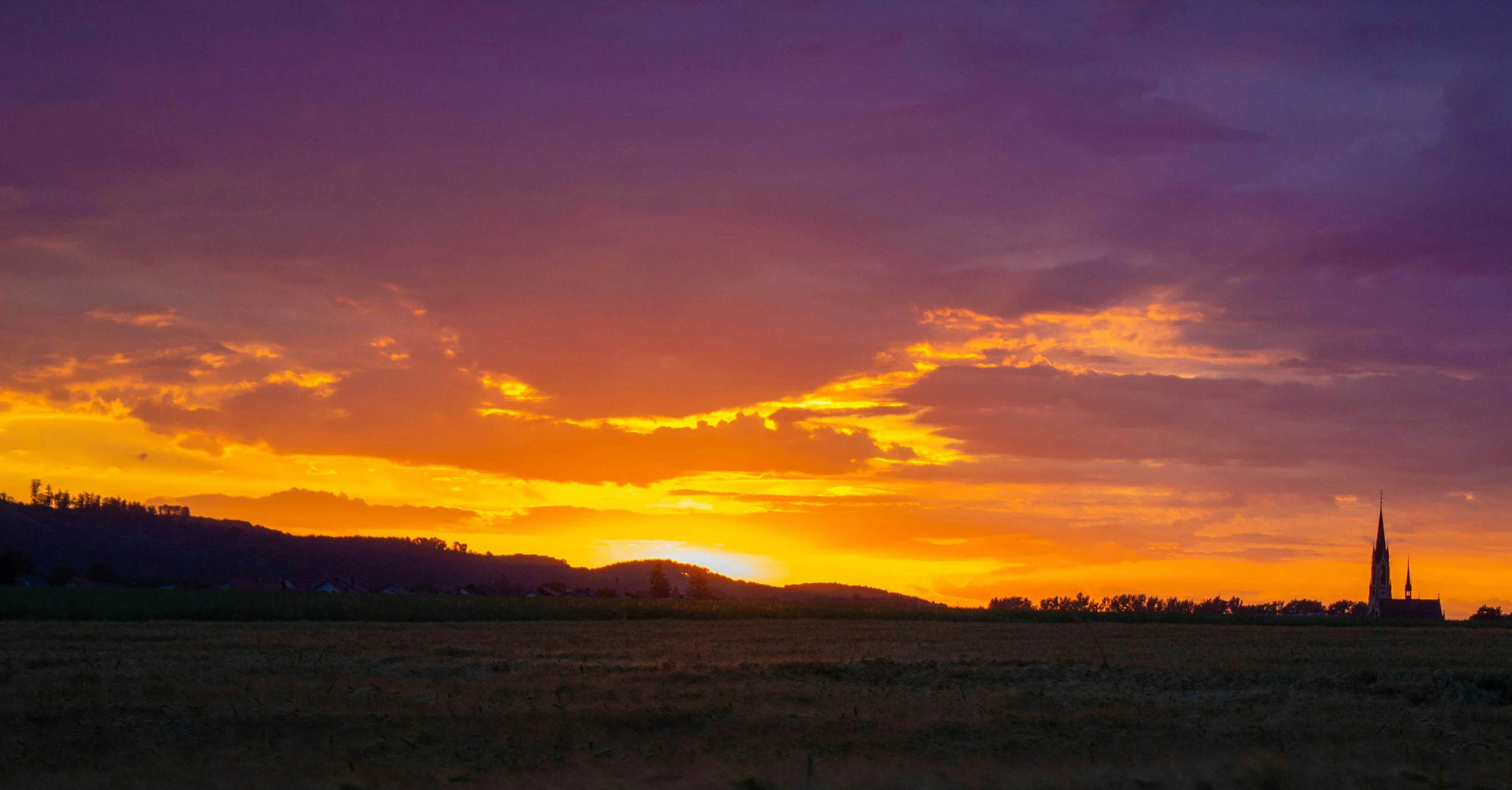 a very pretty sunset over some big hills