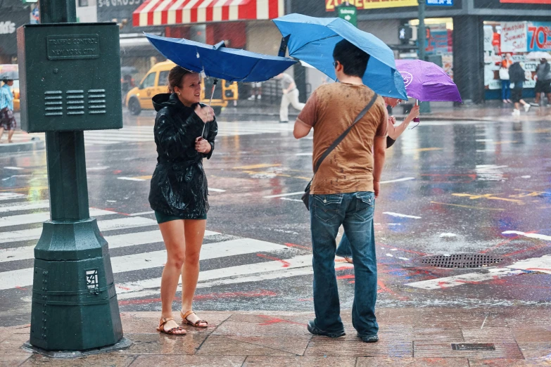 two people are standing under umbrellas in the rain