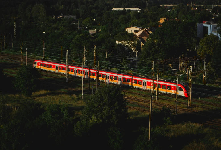 the train is traveling down the track past the forest