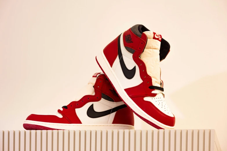 the pair of shoes is red and white with a black shoelace