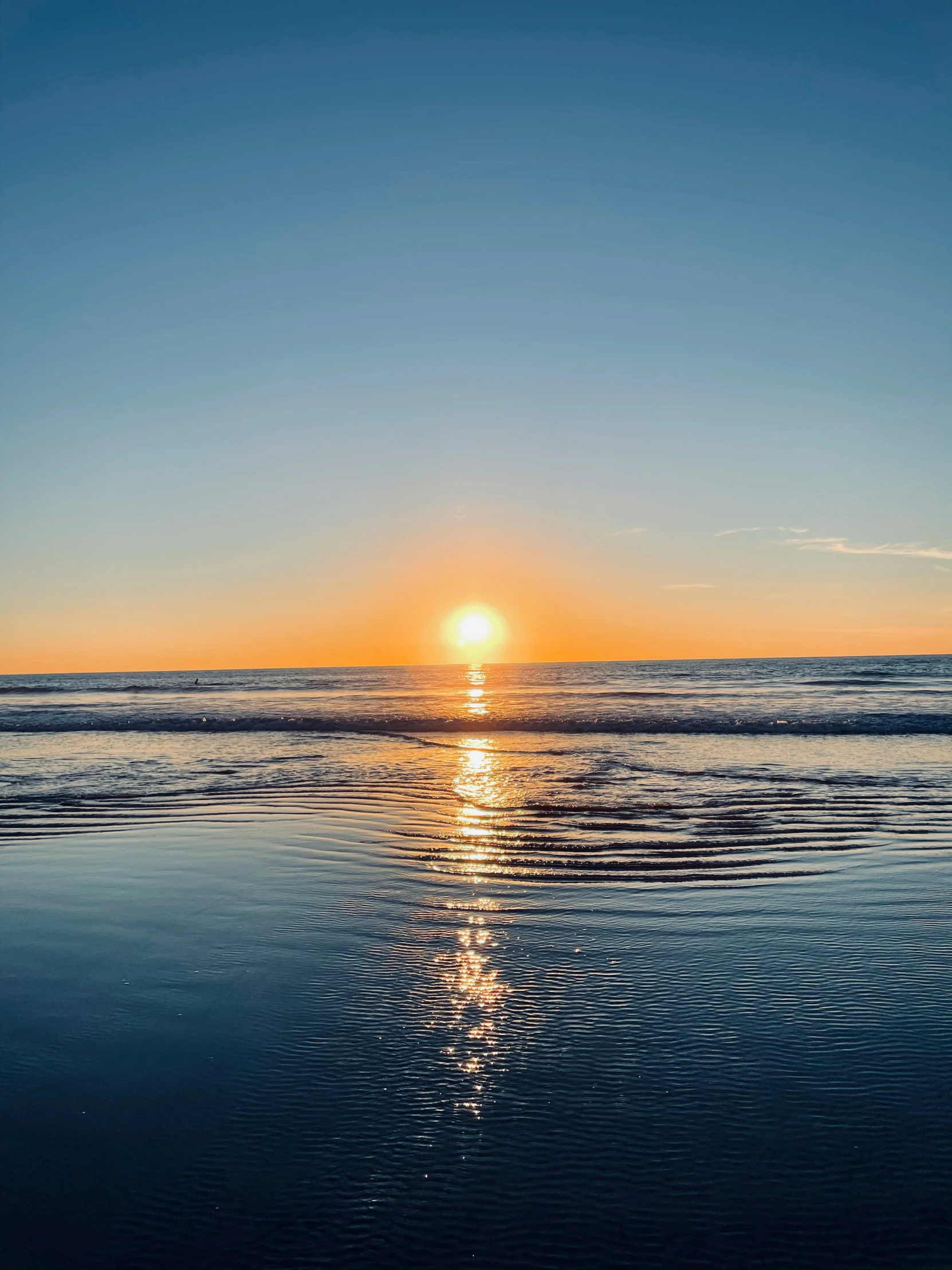 a sunset with the sun reflecting off of the water