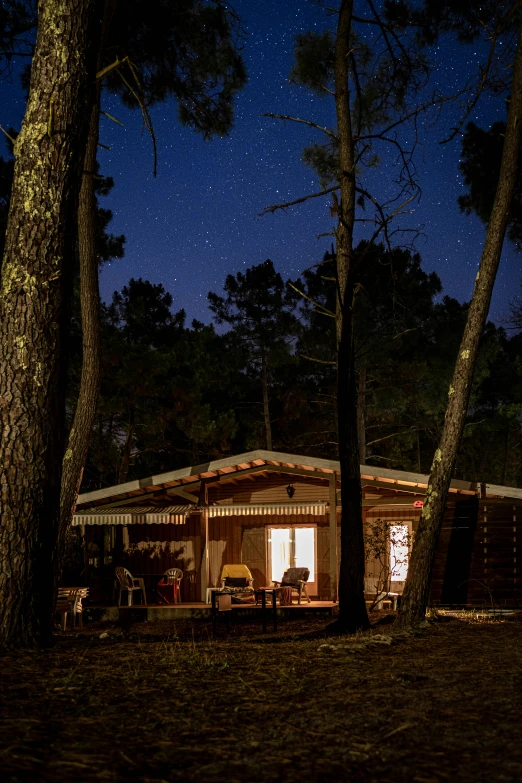 a cabin in the woods lit up at night