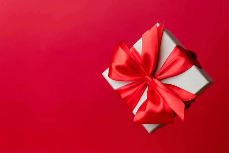 a white box with a red bow and some sort of paper