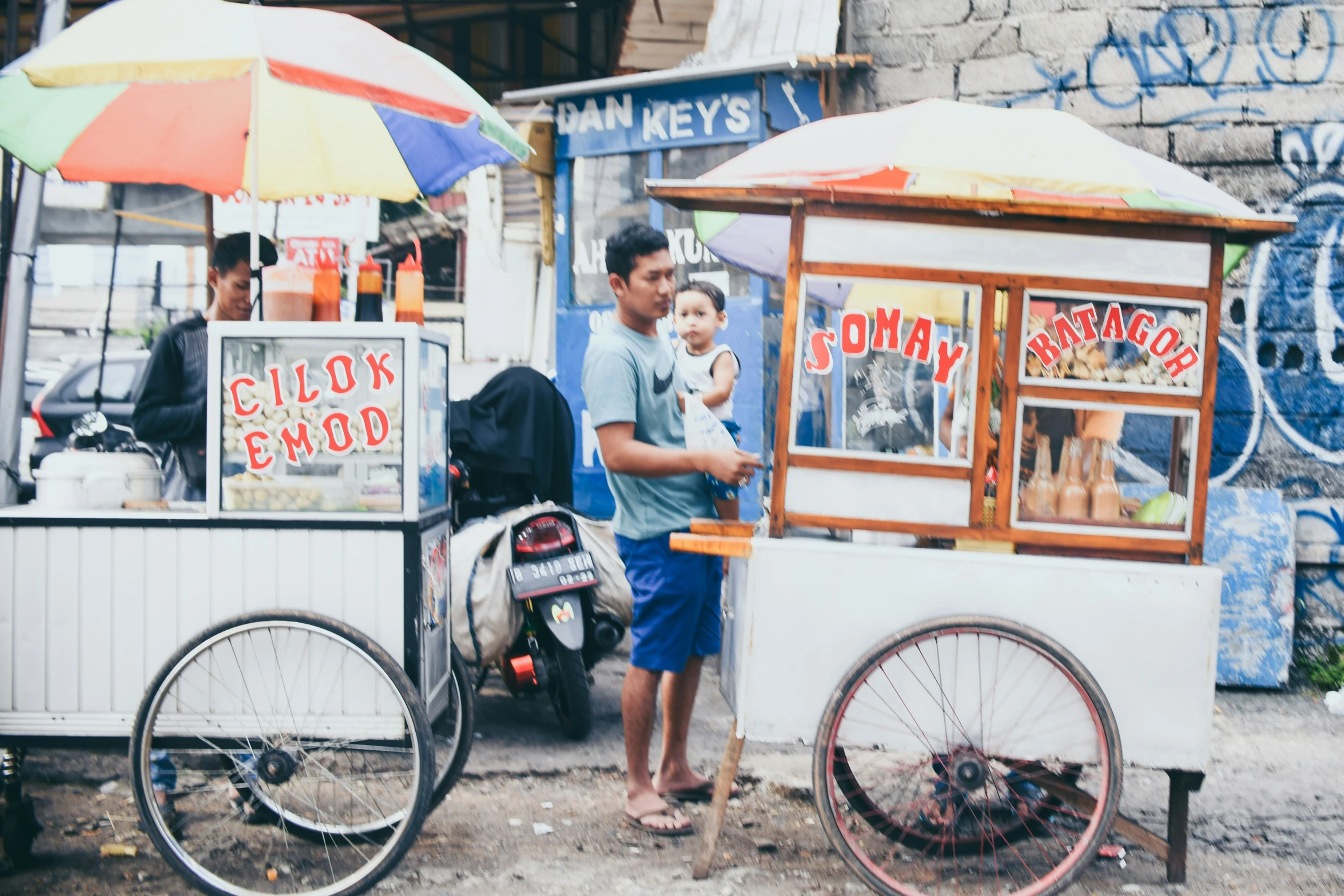 man and little boy standing outside of an outdoor kiosk