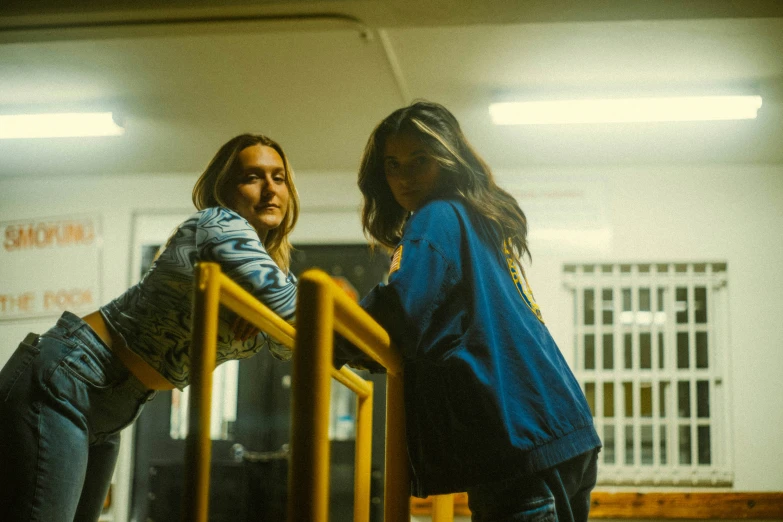 two women leaning over the rail in a school