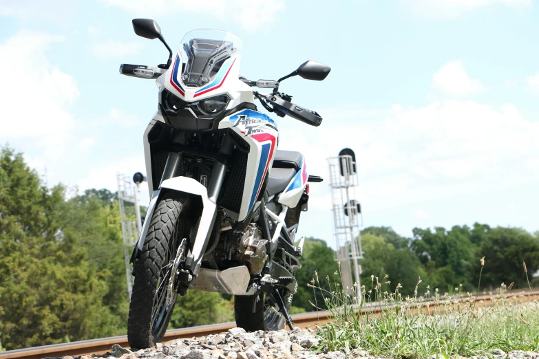 a white and blue motorcycle parked on a train track