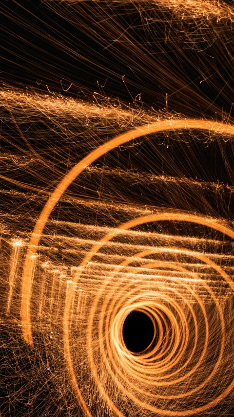 light trails against a black background that shows a spiral of fire