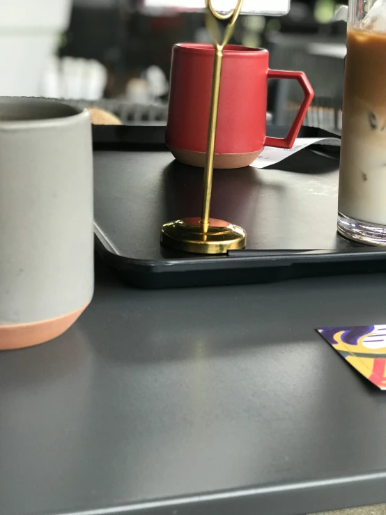 cups and a coaster on the counter of a coffee shop