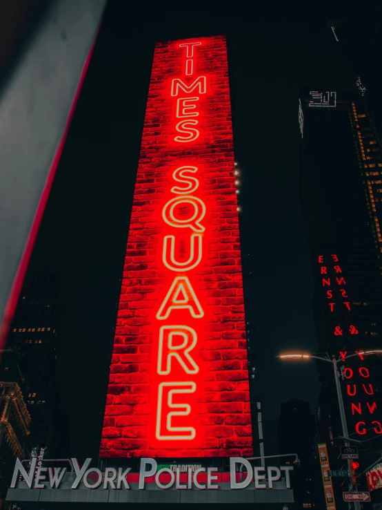 a neon red sign on top of the brick building
