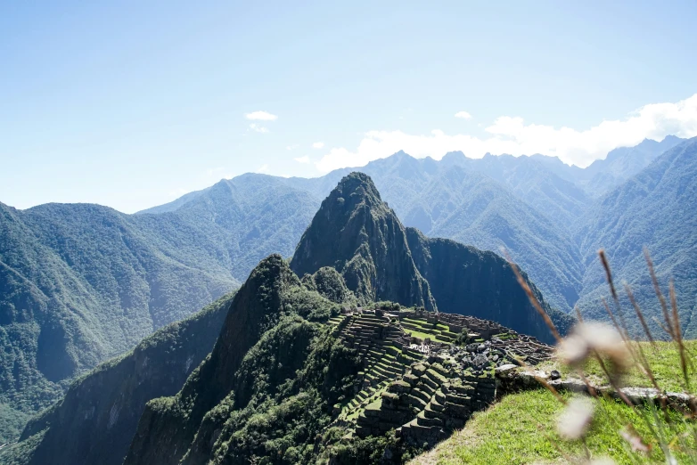 the mountains are filled with trees, grass and a road