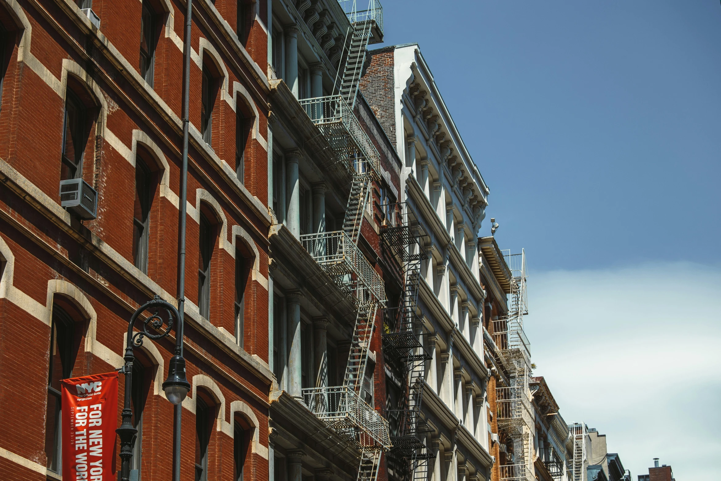 a city street with signs and a row of buildings