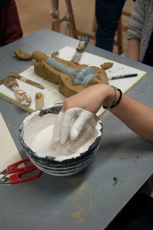 a person is working with a piece of art in his studio