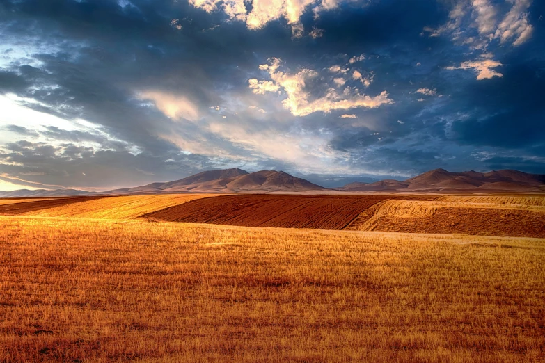 a beautiful view of some mountains and a field