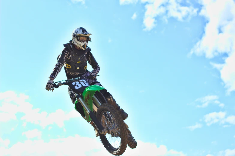 a man flying through the air while riding a dirt bike