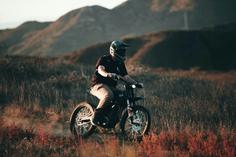 a man is riding his motorcycle through the mountain meadow