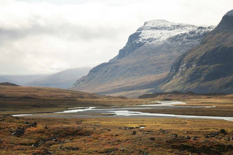 a mountain range with snow capped mountains in the background