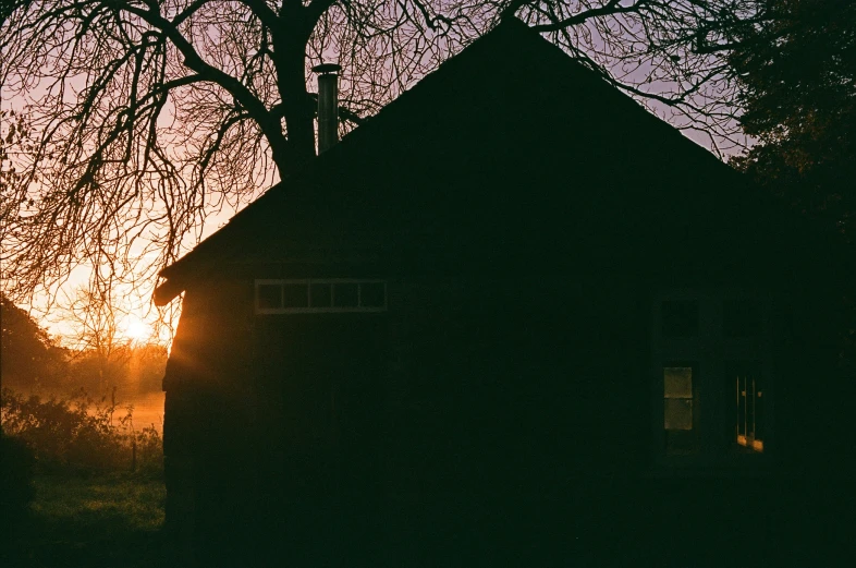 the sun rises over the silhouette of a building