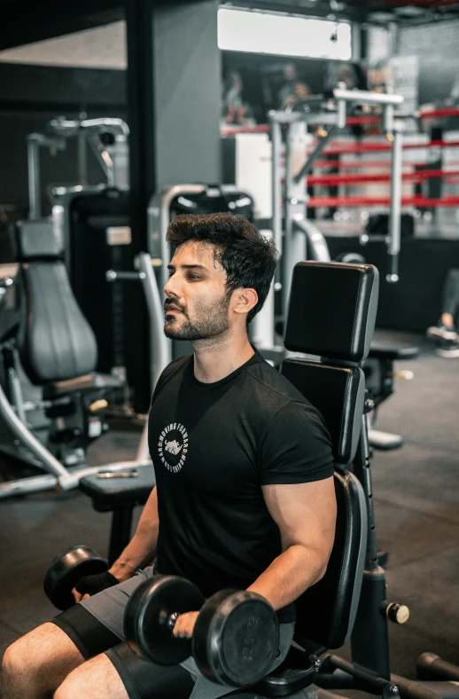 a man sits on a bench holding a dumb machine