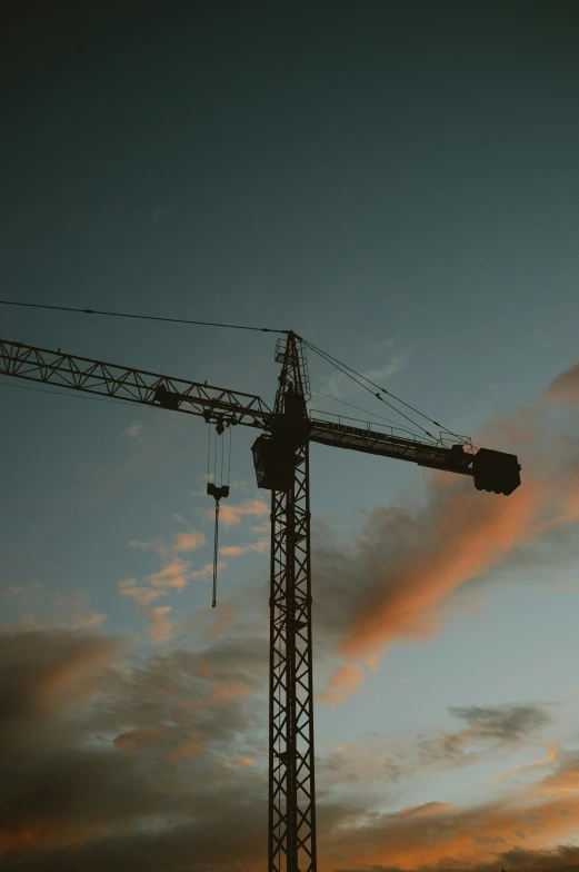 a crane is shown under a cloudy sky